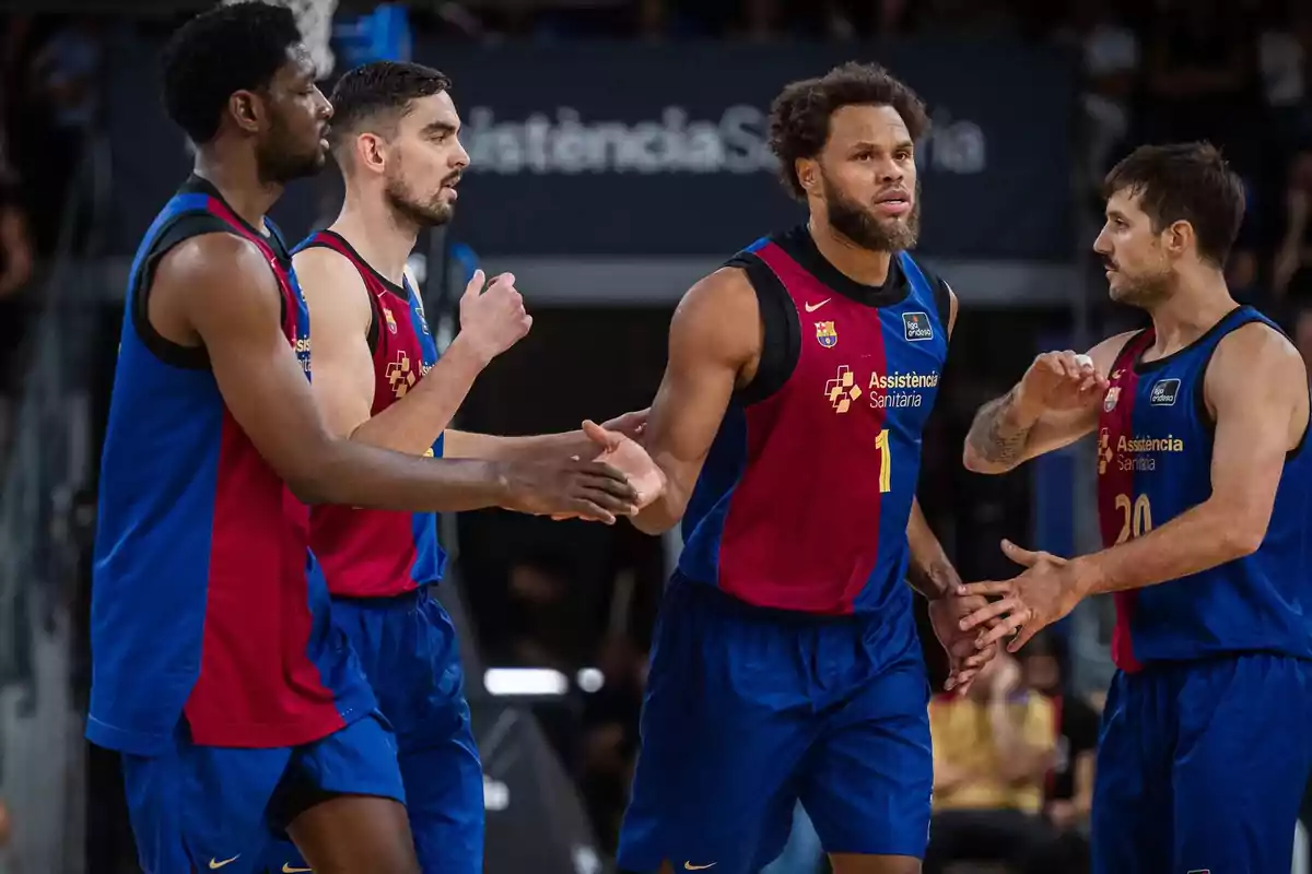 Jugadores de baloncesto del equipo FC Barcelona celebrando en la cancha durante un partido.