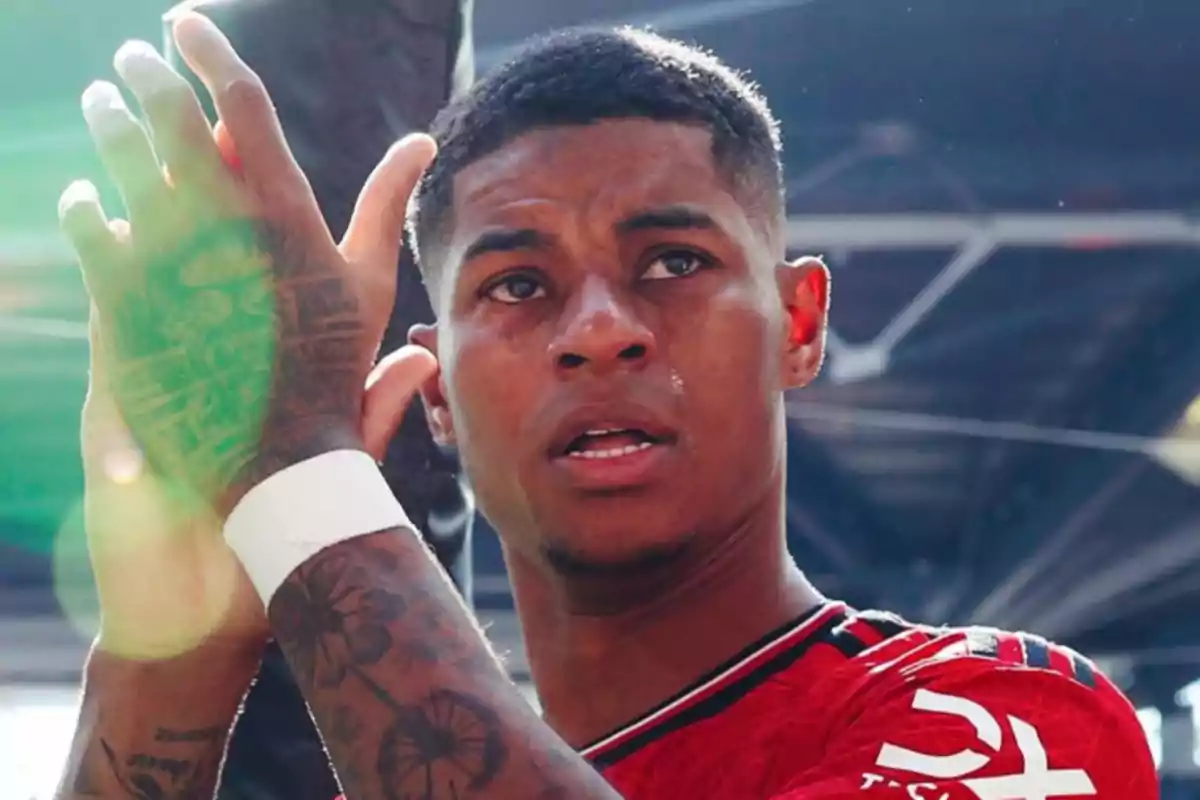 Soccer player wearing a red jersey clapping and looking forward Soccer player wearing a red jersey clapping and looking forward