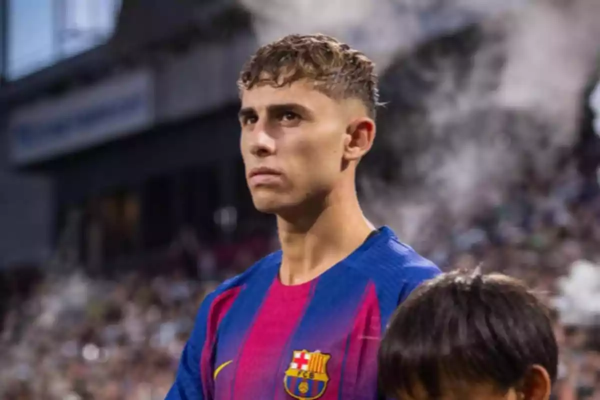Jugador de fútbol con uniforme del FC Barcelona mirando al frente en un estadio lleno de espectadores