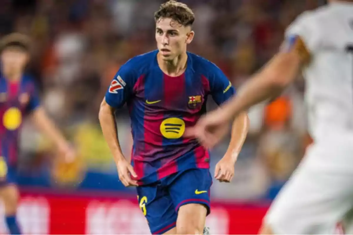 Jugador del Barcelona con uniforme azul y rojo corriendo en un partido de fútbol