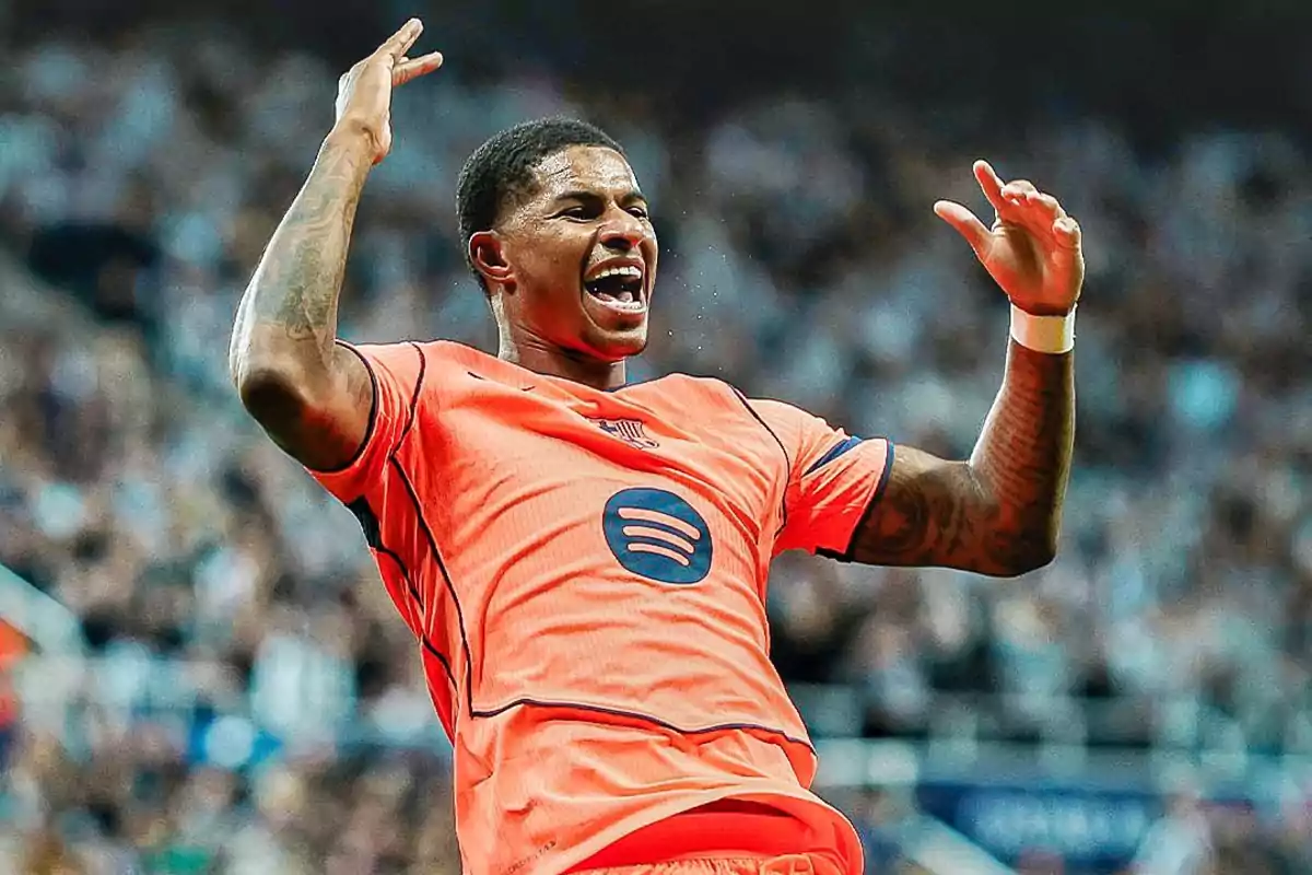 Futbolista celebrando un gol con el uniforme naranja del FC Barcelona en un estadio lleno de espectadores