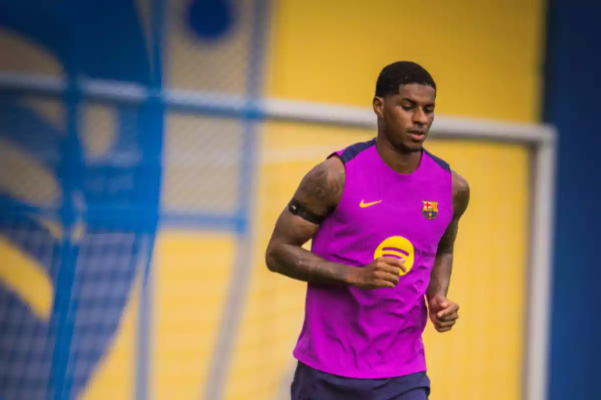 Futbolista entrenando con camiseta morada del FC Barcelona en un campo deportivo