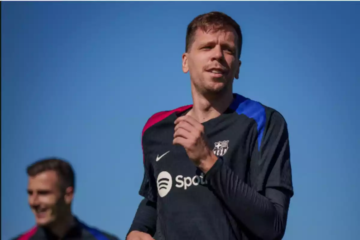 Un jugador de fútbol entrenando con una camiseta del FC Barcelona bajo un cielo despejado.