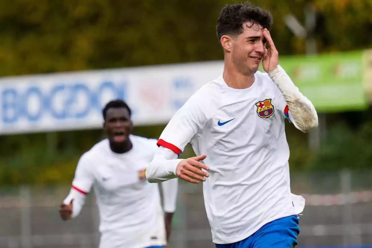 Un joven con la camiseta blanca del Barça celebrando un gol y por detrás un compañero