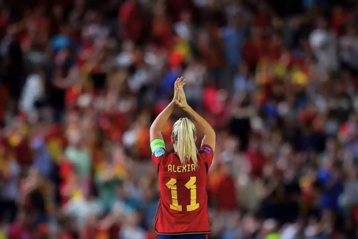 Alexia Putellas ante la afición de la Selección Española, vestida de rojo con el dorsal '11' amarillo a la espalda