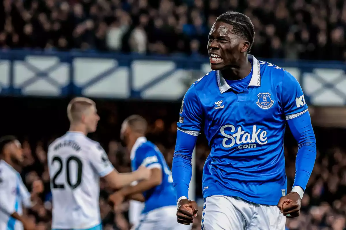 Amadou Onana celebrando un gol con la camiseta azul del Everton y los puños cerrados enseñando los dientes