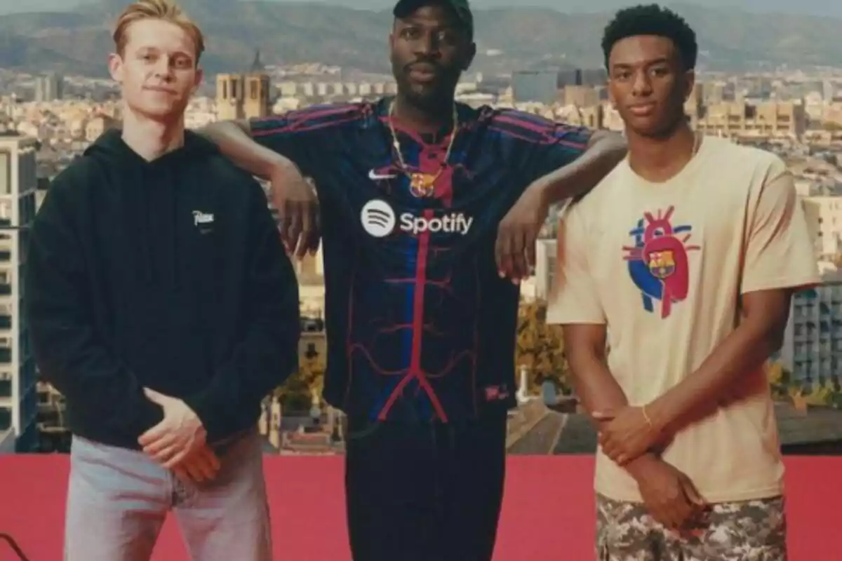 Tres personas posan frente a una ciudad, una de ellas lleva una camiseta del FC Barcelona con el logo de Spotify.