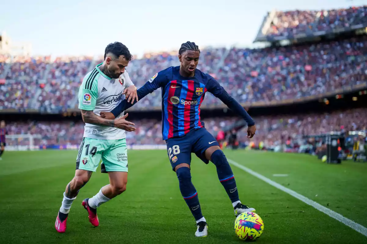 El jugador del Barça Alejandro Balde protegiendo un balón ante el jugador del Osasuna Rubén García