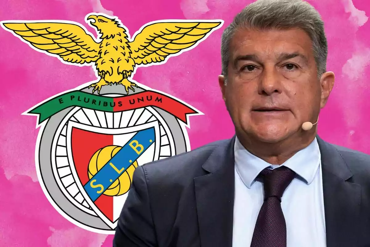 Un hombre con traje y corbata está frente a un fondo rosa que muestra el escudo del club de fútbol Benfica.