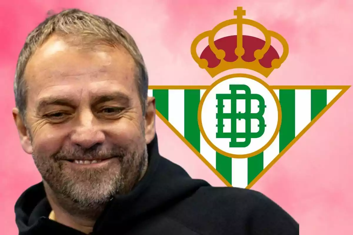 A smiling man in front of the Real Betis crest with a pink background.