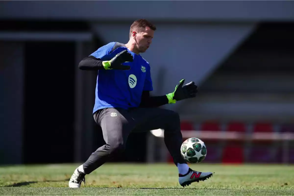 Un portero de fútbol entrenando en el campo con guantes y uniforme deportivo mientras controla un balón. Un portero de fútbol entrenando en el campo con guantes y uniforme deportivo mientras controla un balón.