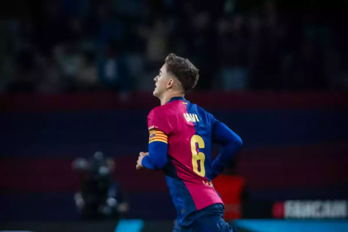 Jugador de fútbol con el número 6 en la camiseta corriendo en el campo durante un partido.