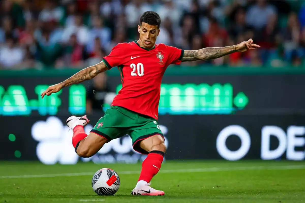 Jugador de fútbol con el uniforme de la selección de Portugal pateando un balón en un estadio.