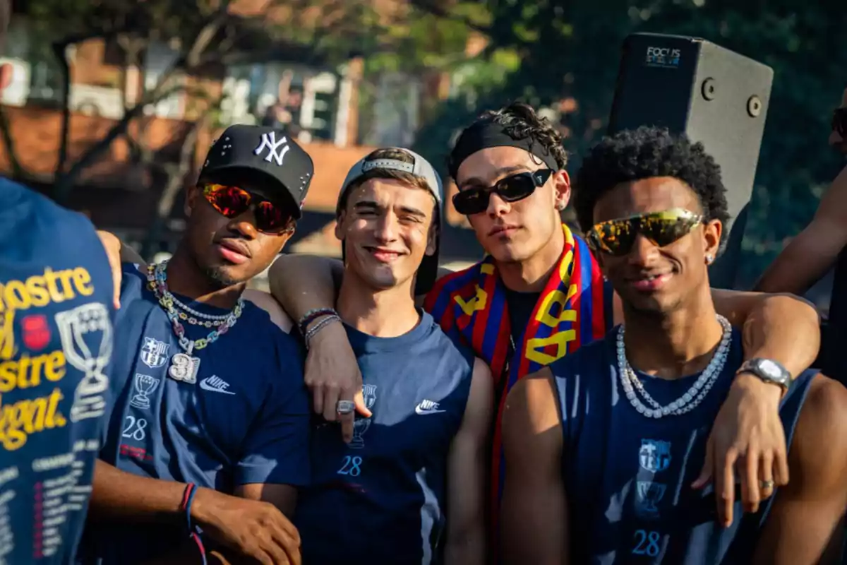 A group of four young people posing together outdoors with blue jerseys and striking accessories. A group of four young people posing together outdoors with blue jerseys and striking accessories.