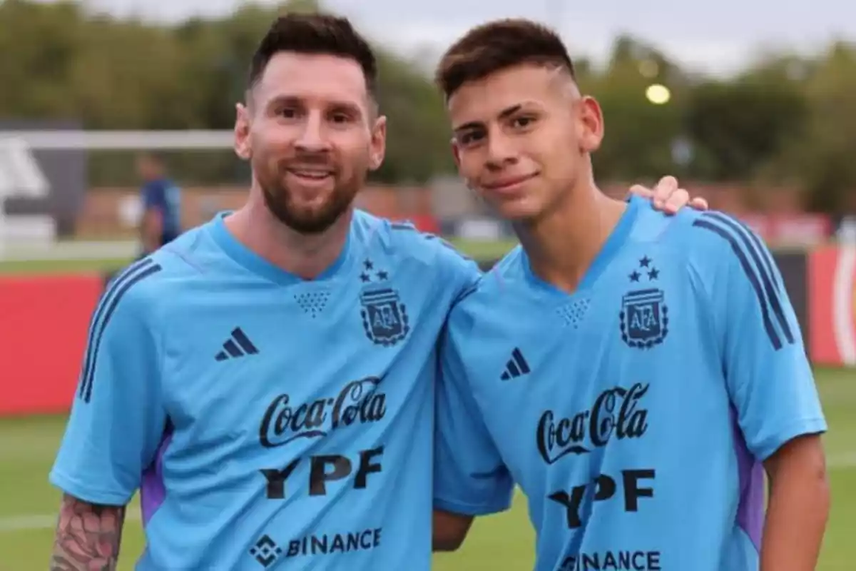 Dos hombres argentinos posando juntos con las camisetas de entrenamiento de la selección argentina de futbol