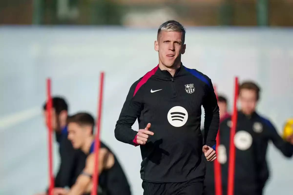 A soccer player training in a black FC Barcelona uniform on a training ground.