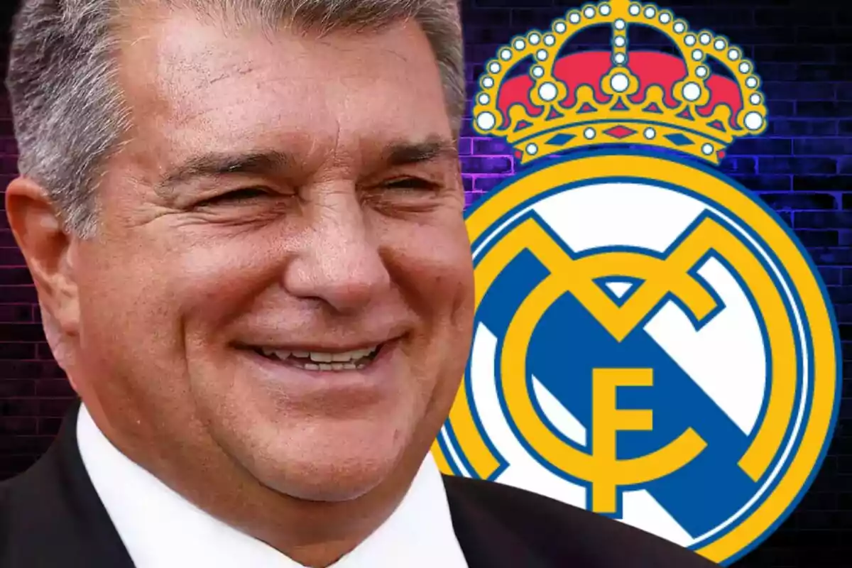 Un hombre sonriendo frente al escudo del Real Madrid.