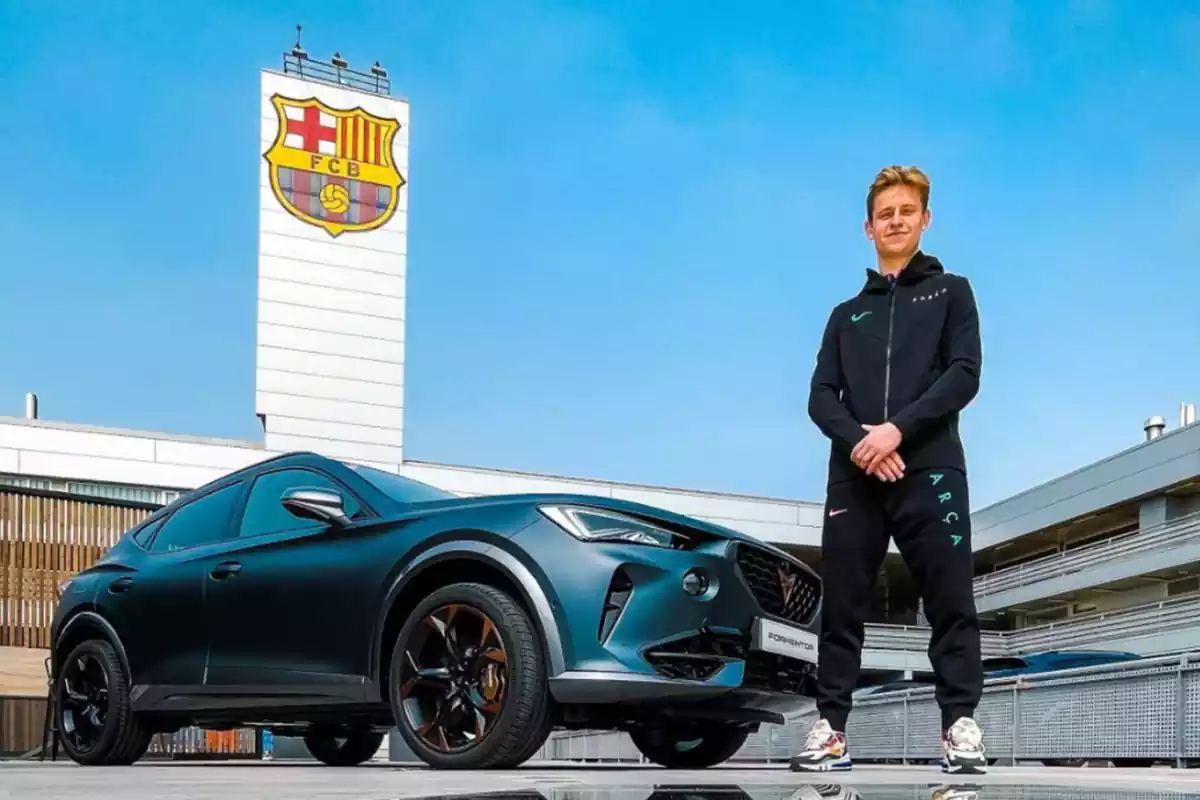 El jugador del Barça De Jong posando al lado de un coche de la marca Cupra, con el escudo del club en el cielo