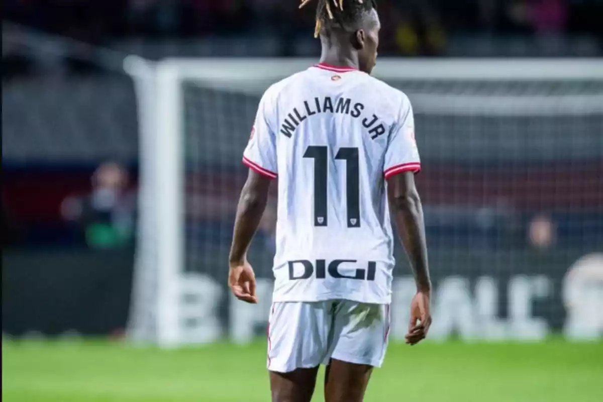 Jugador de fútbol con la camiseta número 11 y el nombre "Williams Jr" en la espalda, de pie en el campo frente a una portería.