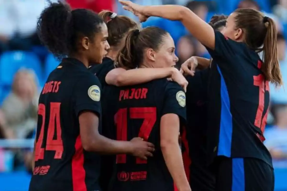 Jugadoras de fútbol celebrando un gol en equipo.