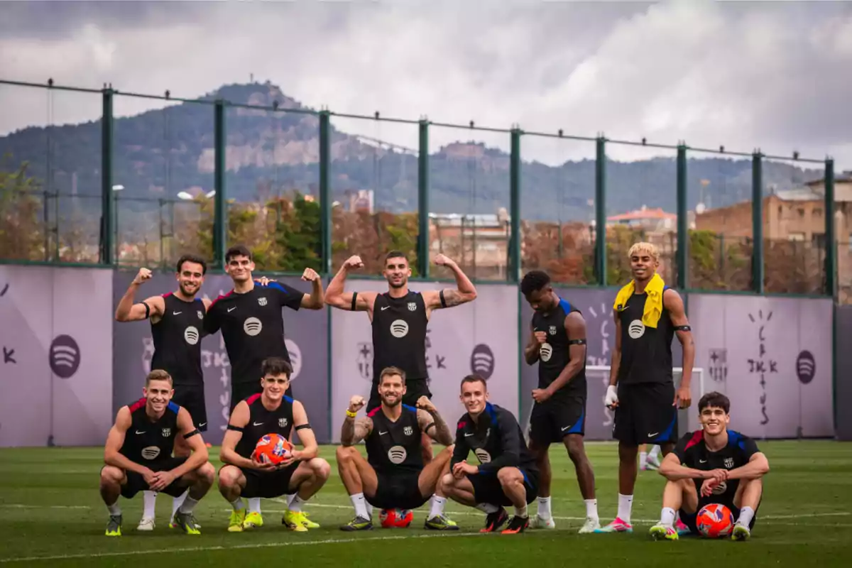 Un grupo de jugadores de fútbol posando en un campo de entrenamiento con montañas al fondo. Un grupo de jugadores de fútbol posando en un campo de entrenamiento con montañas al fondo.