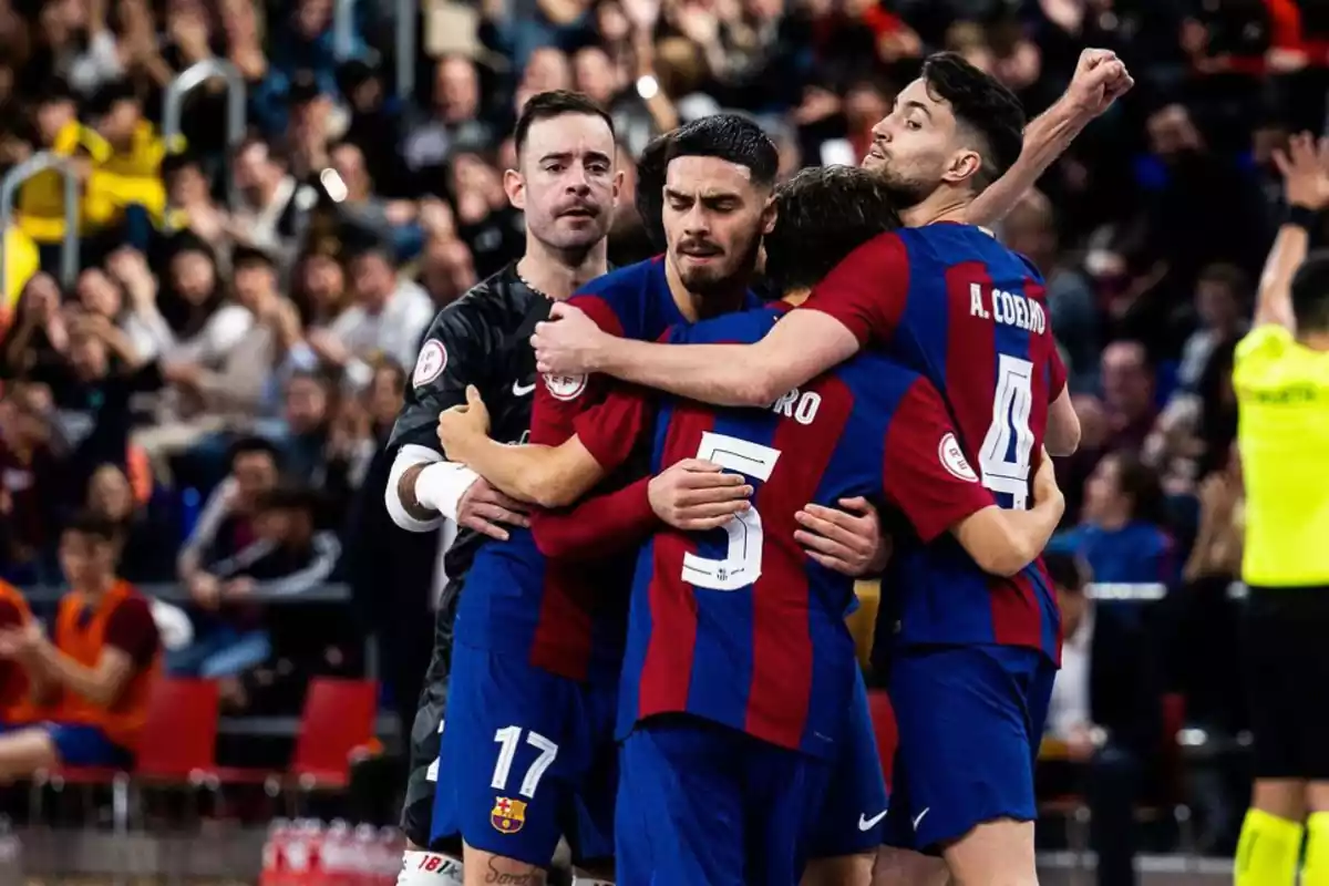 FC Barcelona futsal celebrando un gol delante de mucha afición y todos abrazados