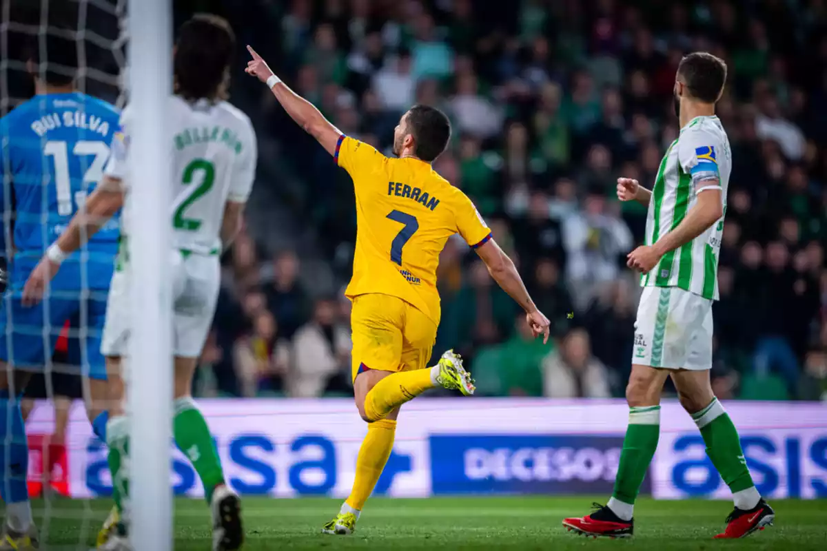 Ferran Torres celebrando un gol con el Barça señalando con el dedo hacia la grada con dos jugadores del Betis mirámdolo