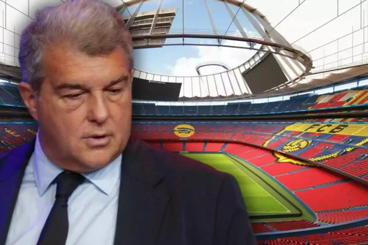 Un hombre con traje y corbata frente a un estadio de fútbol vacío.