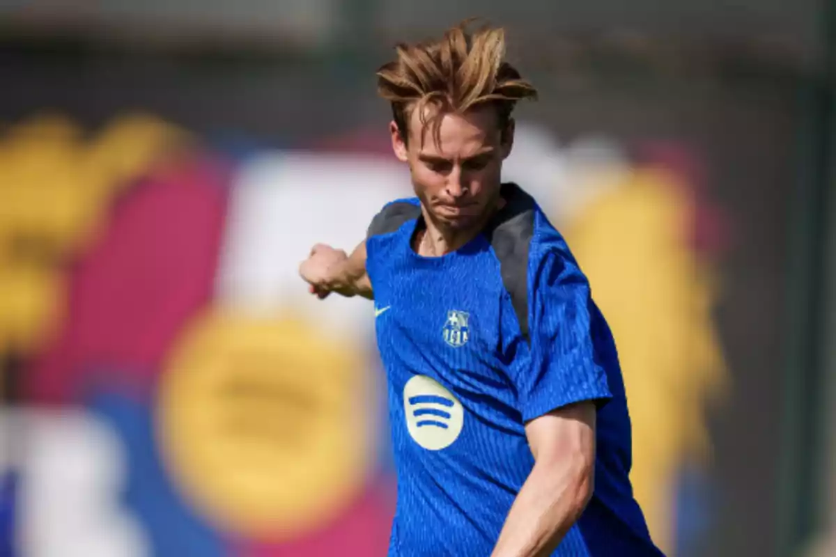 Jugador de fútbol con camiseta azul en acción durante un entrenamiento.