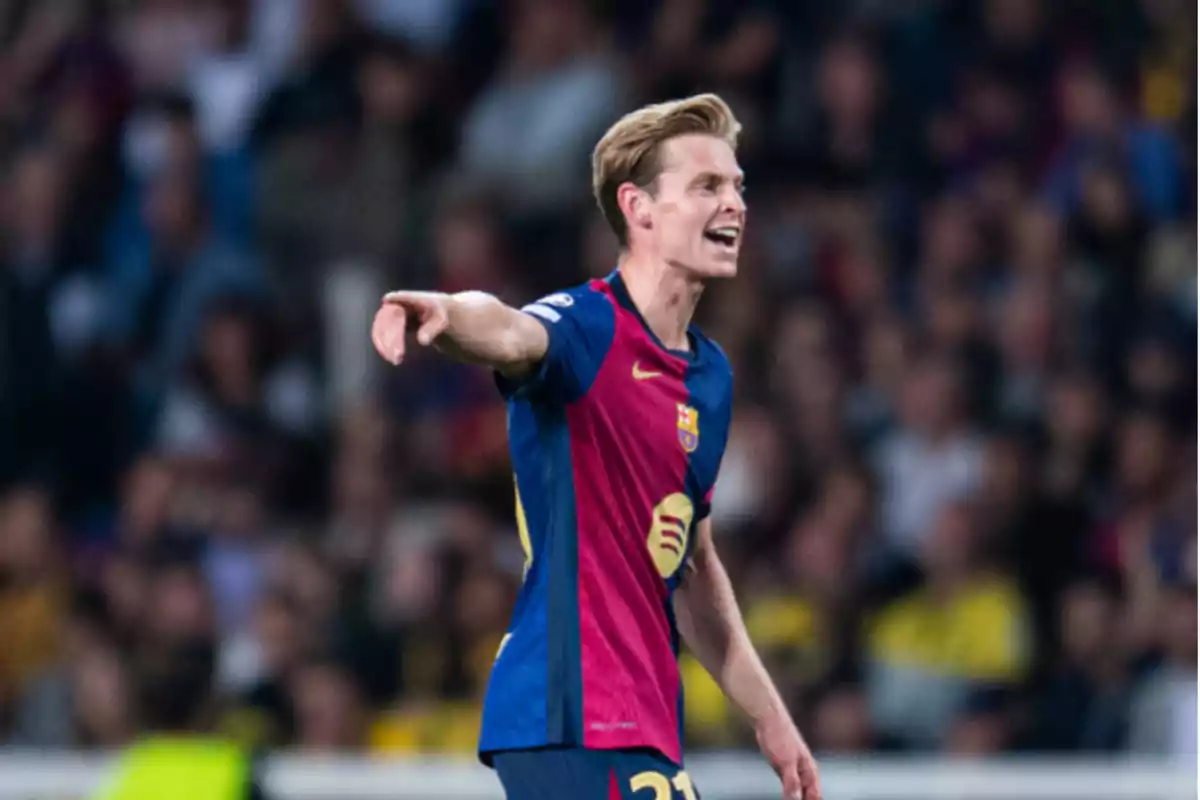 Un jugador de fútbol con el uniforme del FC Barcelona señalando con el brazo extendido durante un partido.