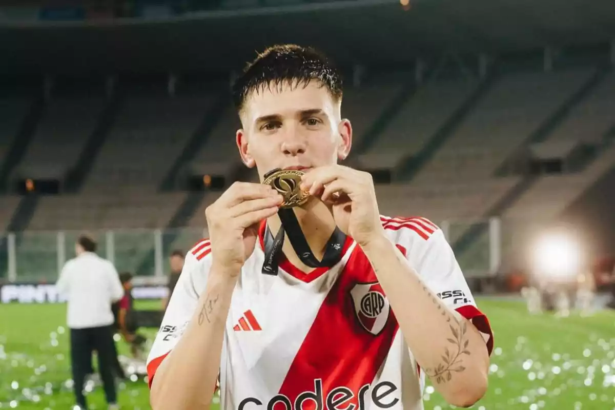 Mastantuono besa una medalla de oro en sus manos con la camiseta roja y blanca de River Plate