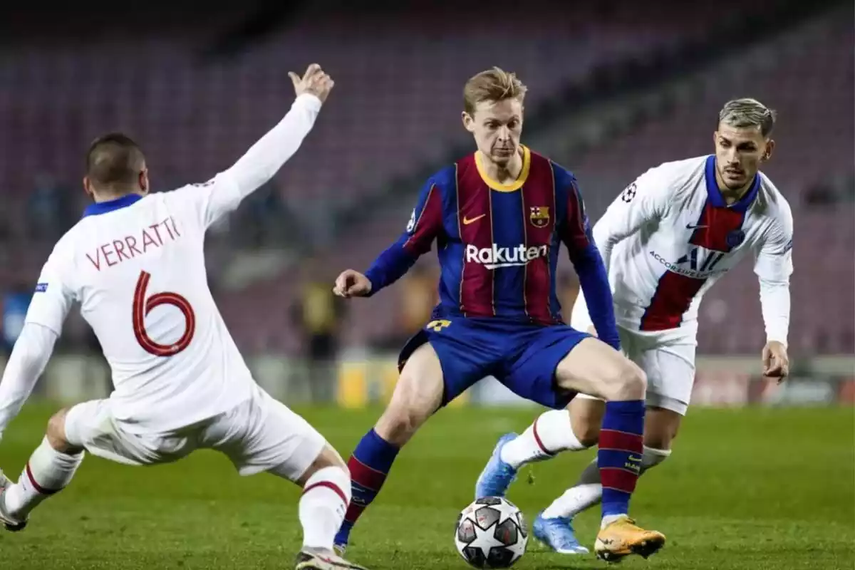 Frenkie de Jong disputando un balón con una indumentaria azulgrana del FC Barcelona y botines anaranjados, ante Verratti y Leandro Paredes, con indumentaria blanca del PSG.