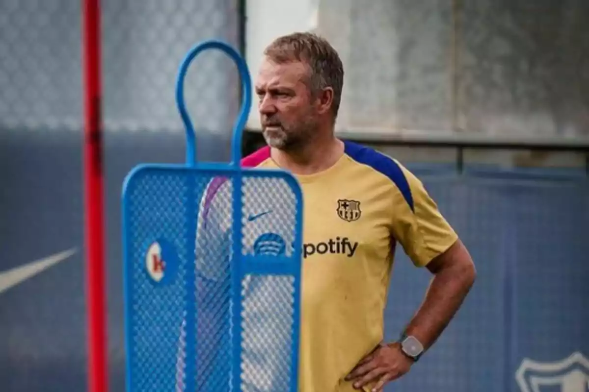 Un hombre con camiseta de entrenamiento del FC Barcelona junto a un maniquí de entrenamiento azul.