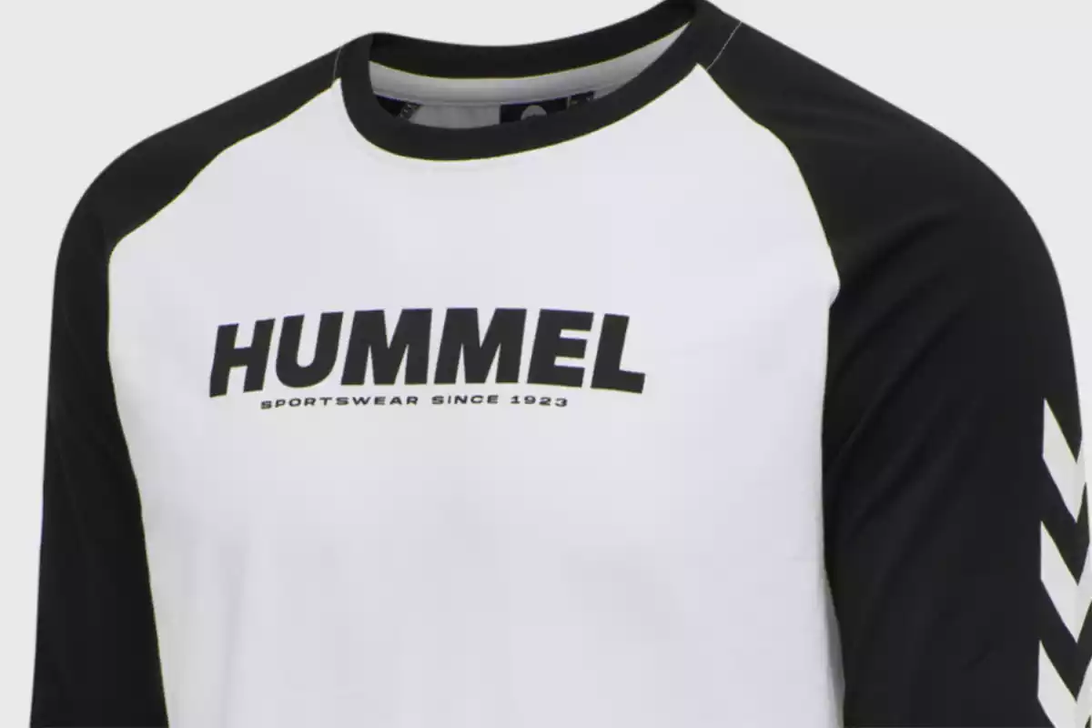 se puede ver una camiseta de la marca hummel de color blanco, con las mangas negras y las negras tambien de color negro