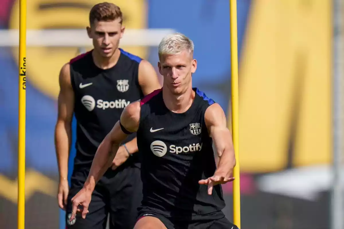 Two FC Barcelona players training in black training shirts with the Spotify logo.