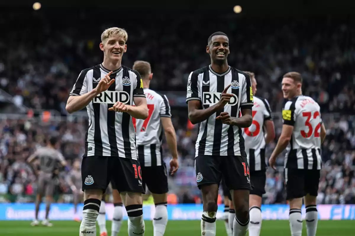 Alexander Isak y Anthony Gordon celebran un gol haciendo un baile vestidos con la equipación negra y blanca del Newcastle United