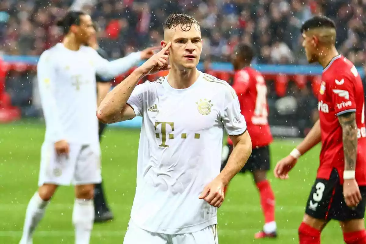 Joshua Kimmich, con la camiseta blanca y dorada del Bayern Munich, haciendo un gesto de celebración