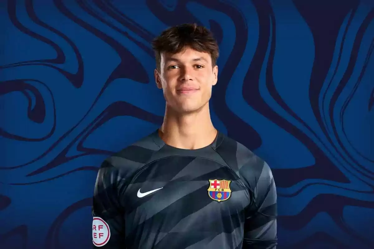 Un joven futbolista con el uniforme del FC Barcelona posando frente a un fondo azul con patrones abstractos.