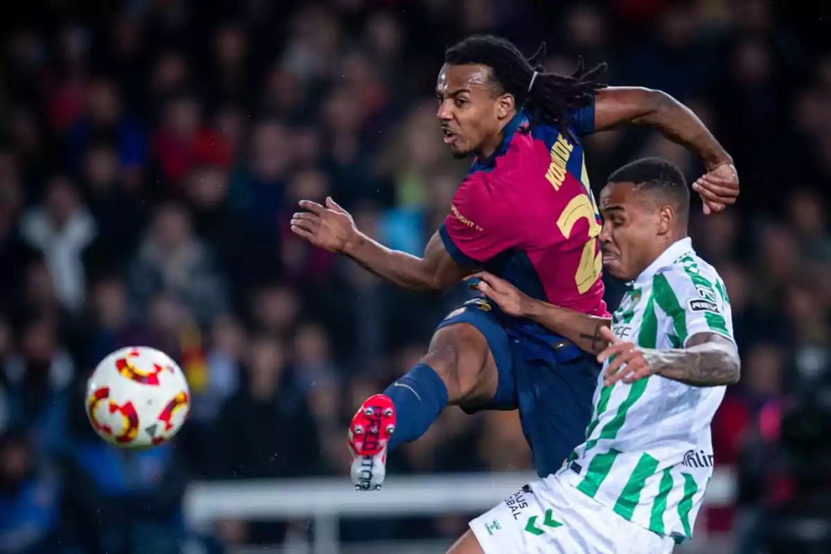 Dos jugadores de fútbol compiten por el balón en el aire durante un partido.