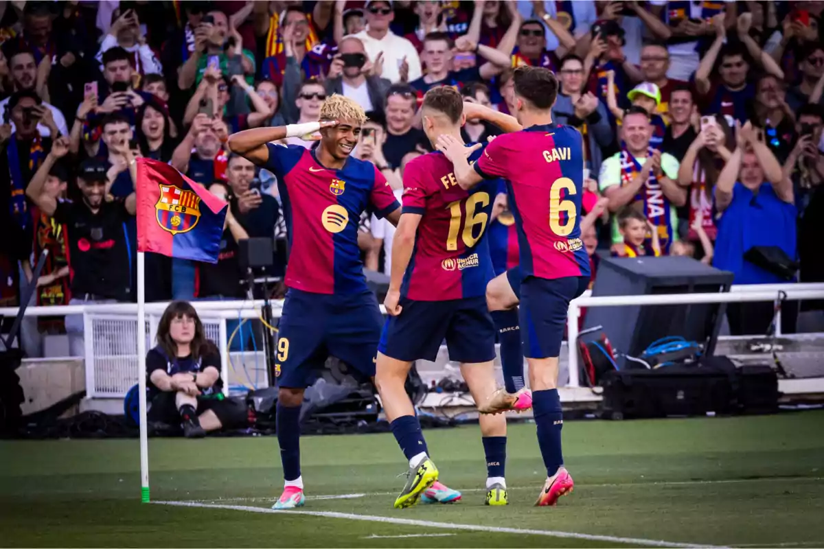 Soccer players celebrating a goal in front of a crowd of fans in a stadium. Soccer players celebrating a goal in front of a crowd of fans in a stadium.