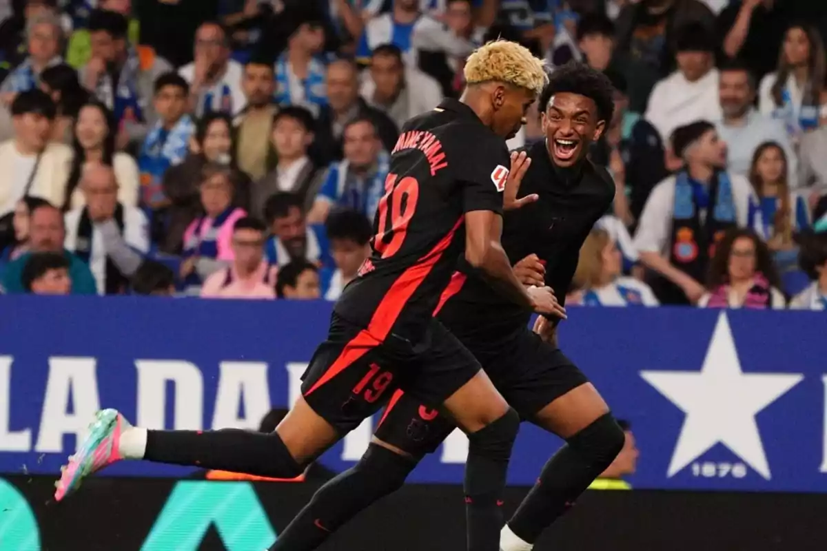 Dos jugadores de fútbol celebran un gol en un estadio lleno de espectadores. Dos jugadores de fútbol celebran un gol en un estadio lleno de espectadores.
