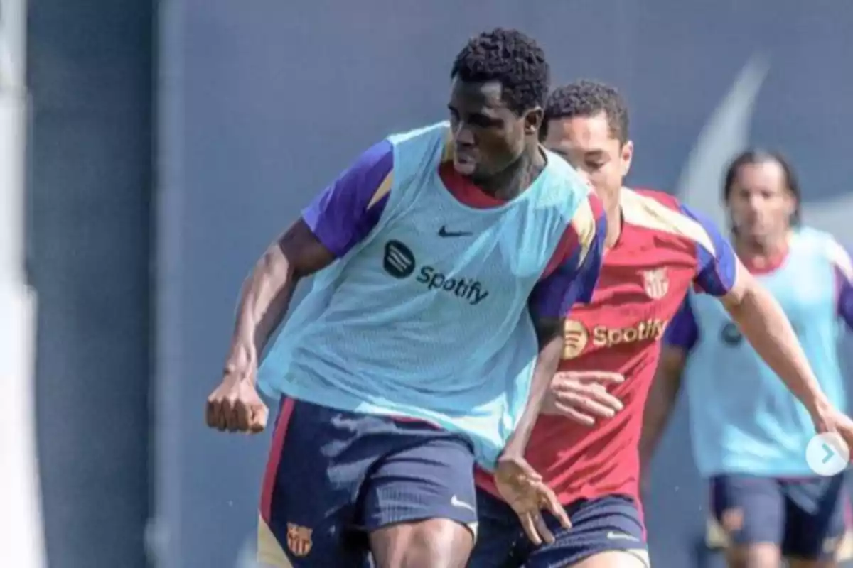 Landry Farré entrena con un peto azul de Spotify presionado por Vitor Roque con la camiseta roja de entreno del FC Barcelona