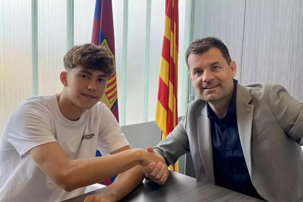 Leo Saca se da la mano con Joan Soler en las oficinas del Barça con la bandera de Catalunya y del Barça detrás