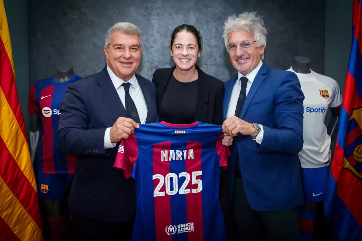 La jugadora del Barça Marta Torrejón, posando sonriendo con una camiseta azulgrana, junto a Joan Laporta y Xavi Puig
