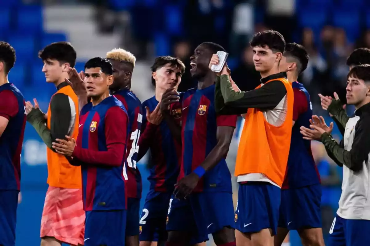 Jugadores de fútbol del FC Barcelona aplaudiendo y celebrando en el campo.