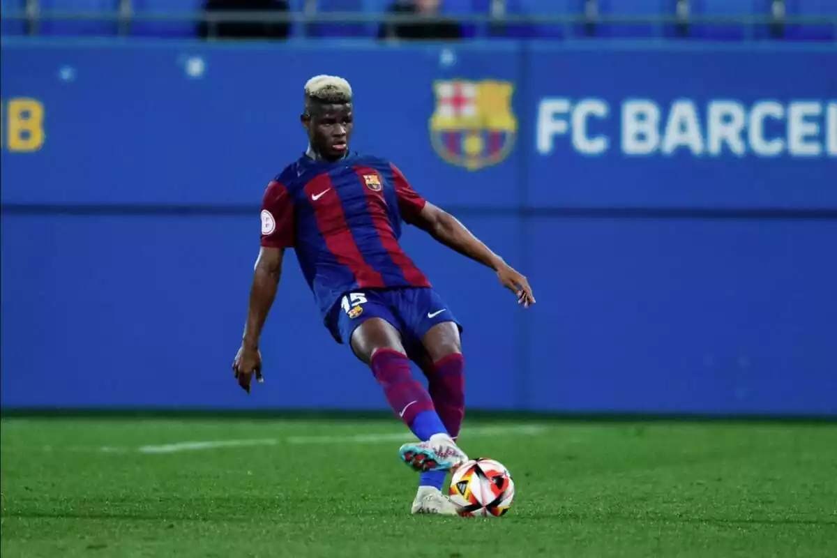 Mikayil Faye, defensa del Barcelona, con una equipación azulgrana pateando un balón