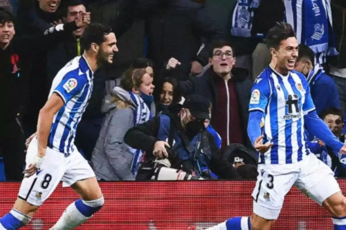 Mikel Merino y Martin Zubimendi celebrando un gol con la equipación blanca y azul de la Real Sociedad