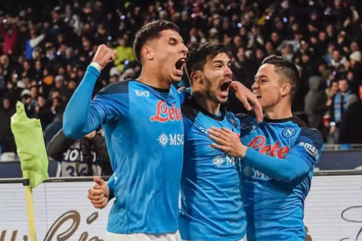 tres jugadores vestidos con una camiseta azul mienttras celebran con cara de felicidad y las bocas abiertas.
