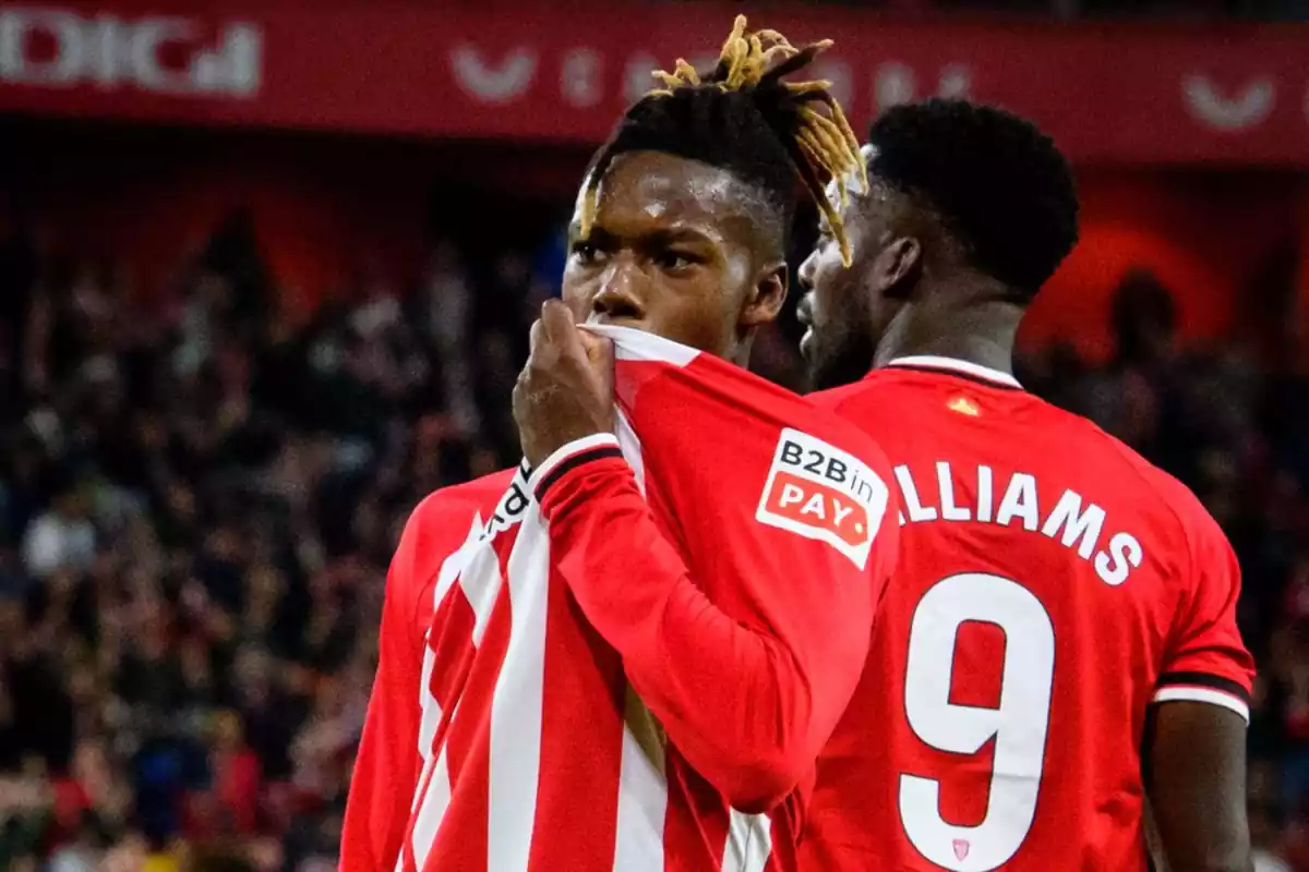 Nico Williams celebra un gol besándose el escudo del Athletic Club vestido con la camiseta blanquirroja del club