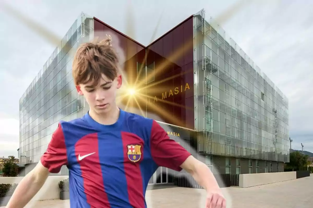 Un joven futbolista con el uniforme del FC Barcelona frente al edificio de La Masia.